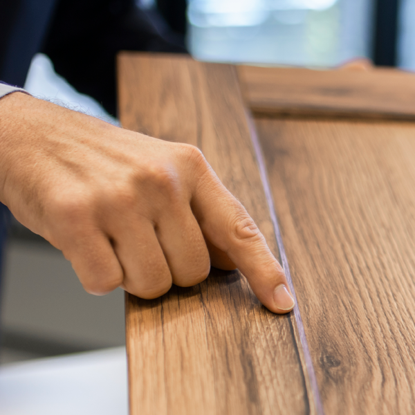 Hand mit Zeigefinger, der auf einen Punkt auf einer Musterplatte zeigt
