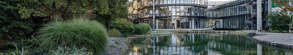 夏特總部辦公室 圓形塔樓，玻璃外牆，前景為池塘