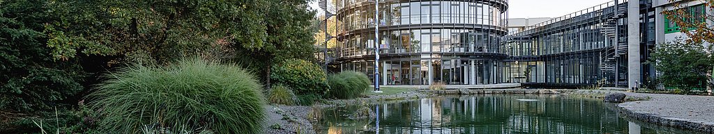Schattdecor Headquarter Büro Rundturm mit Glasfassade und einem Teich im Vordergrund